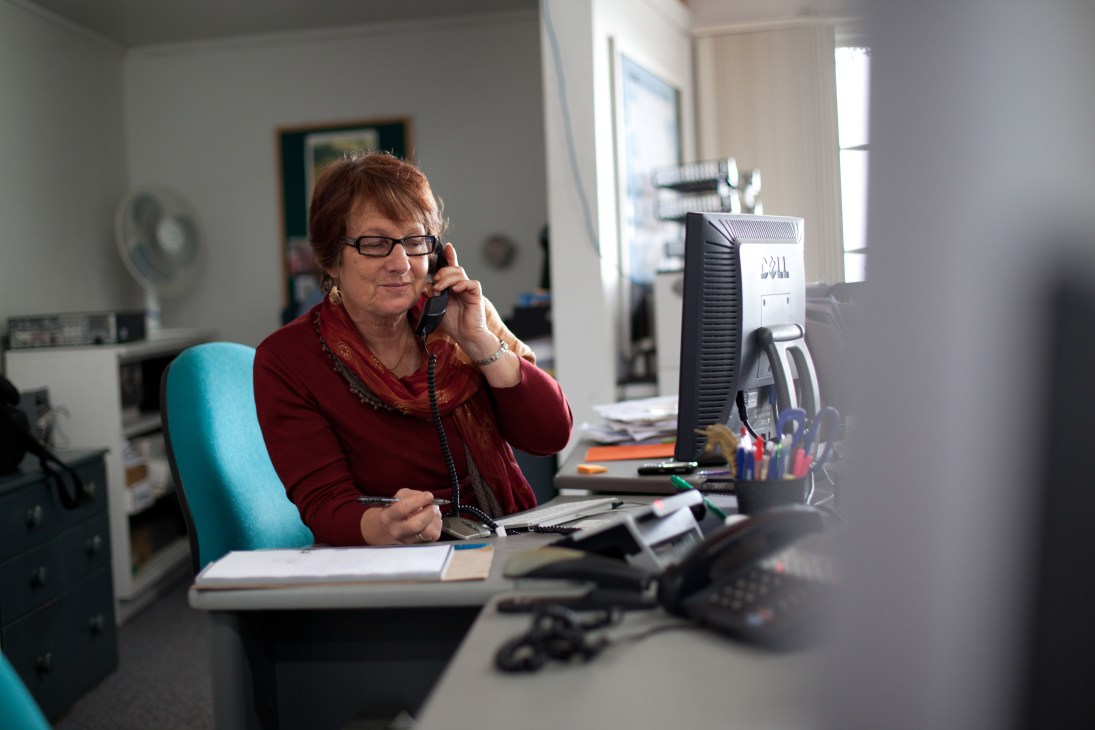 Editor and publisher Liz Waters takes a phone call at her desk in the Gulf News office.