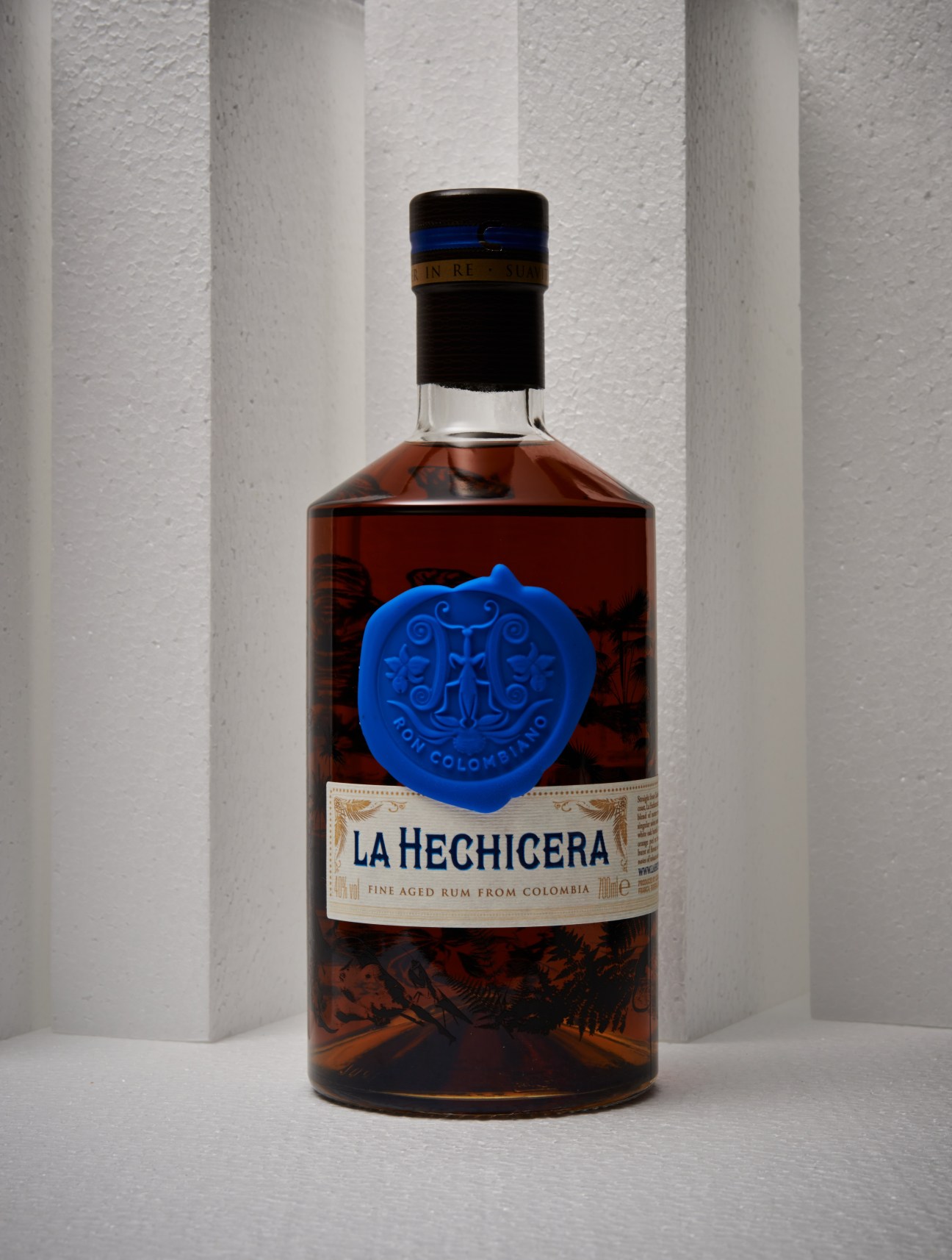 La Hechicera rum bottle with blue wax seal and cream label against white background.