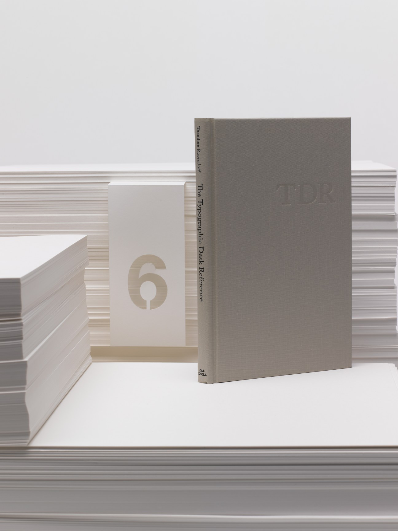Typographic Desk Reference hardback book with grey cover and open pages showing number 6