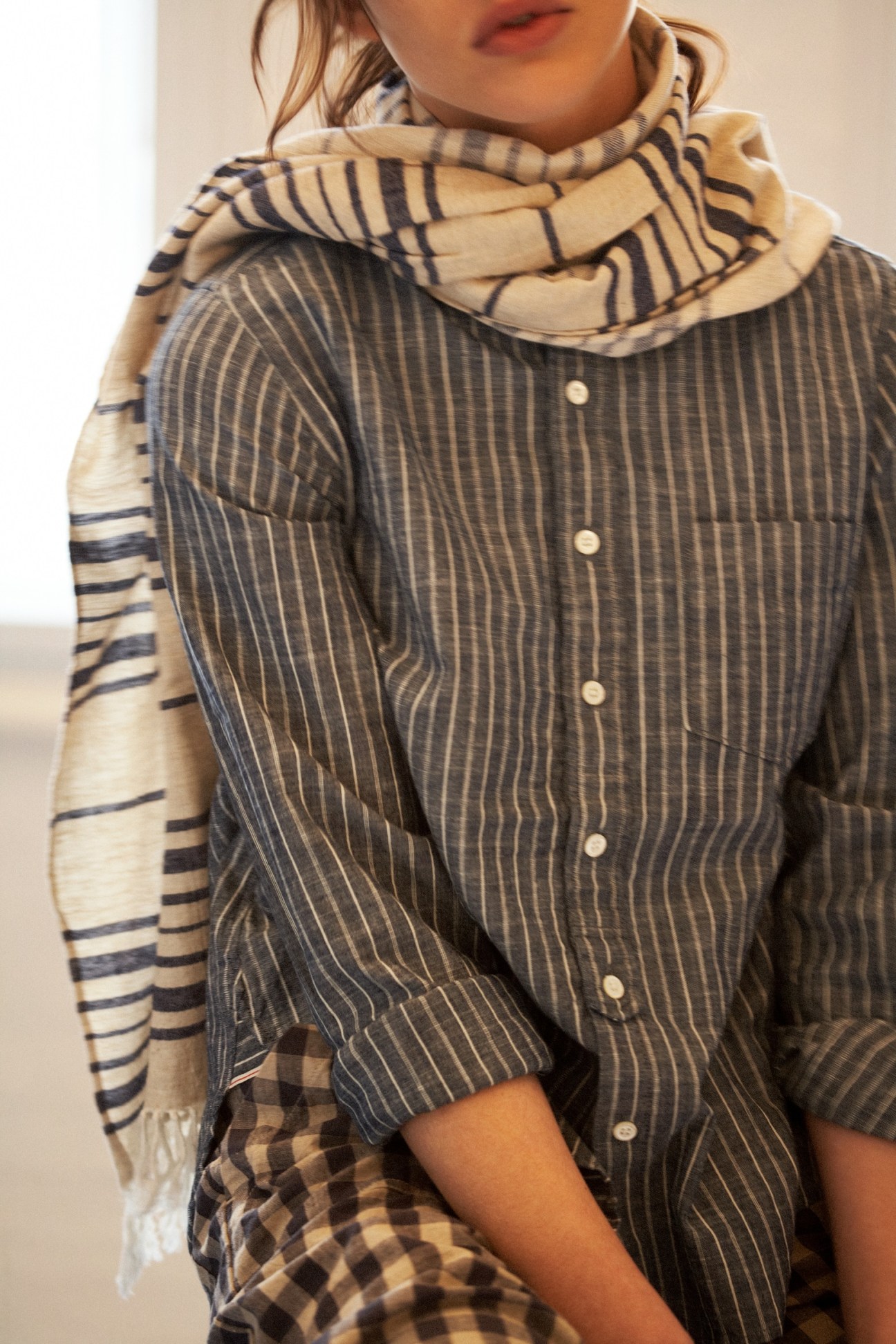 Woman wearing striped Prit shirt with patterned scarf draped around shoulders.
