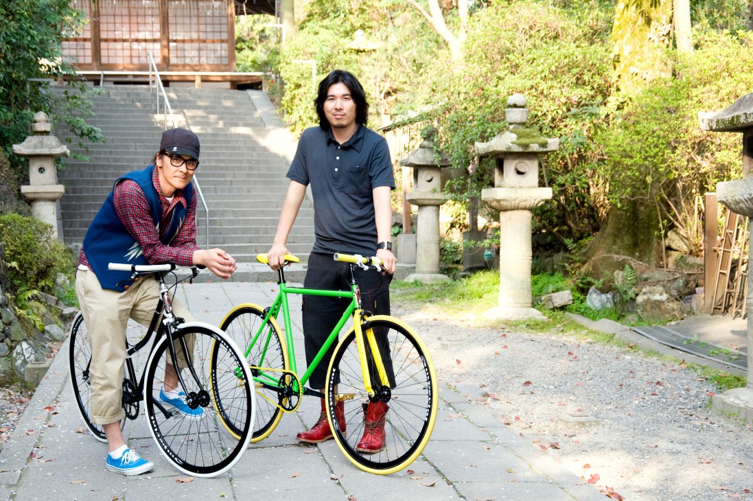 Ryotaro Taniguchi and Kota Sakurai posing with customised Funriki bicycles in a Japanese garden setting.
