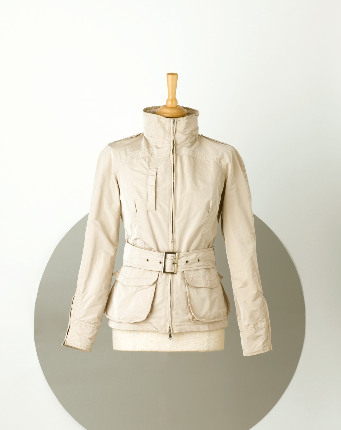 Cream-colored unisex city-sportswear jacket on dress form with belt and cargo pockets.
