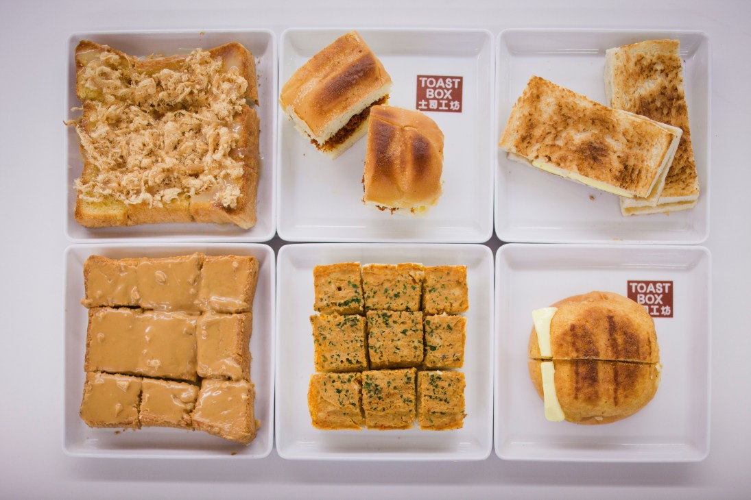 Six white square plates displaying various Toast Box menu items including buttered toast, filled sandwiches, and spreads.