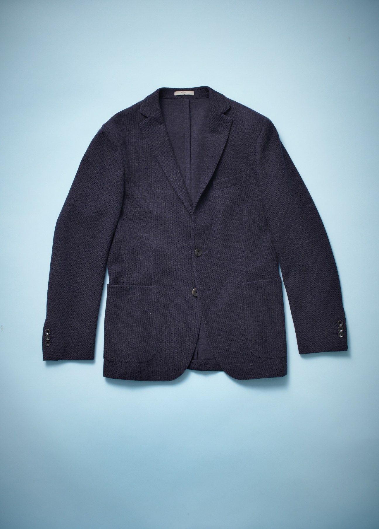 Navy blue Boglioli blazer displayed on light blue background