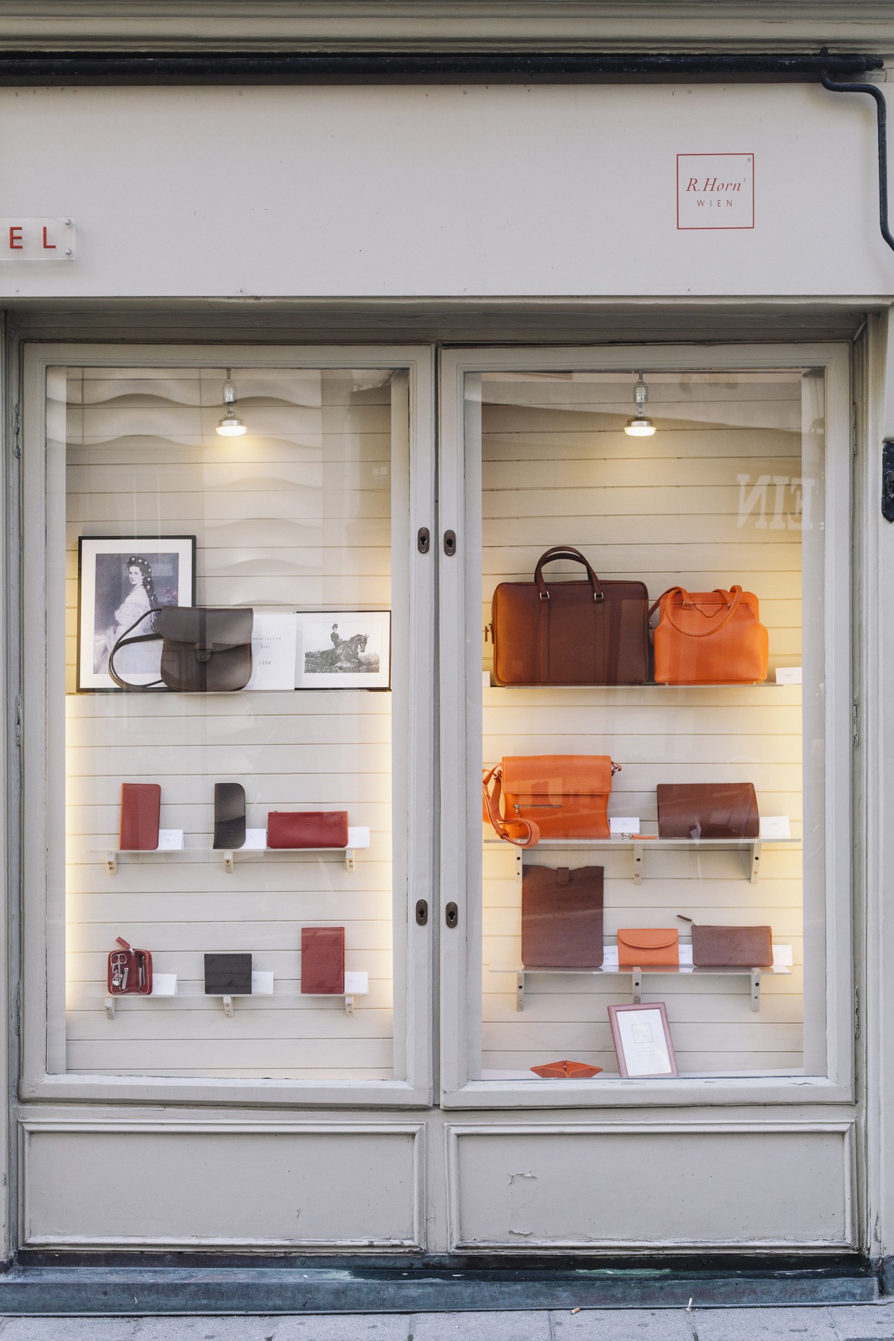 R Horn leather goods storefront in Vienna displaying handbags, briefcases and accessories in brown and orange leather.