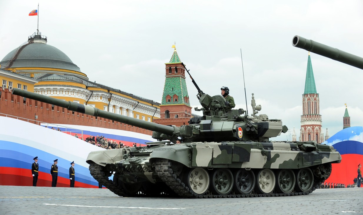 Russian T-90 main battle tank on parade in Red Square with Kremlin towers in background.