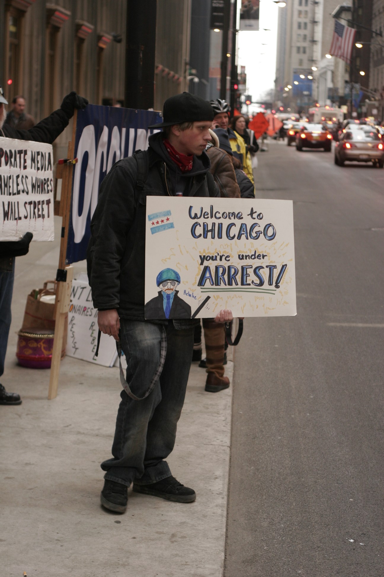 Protester holding sign reading 'Welcome to CHICAGO you're under ARREST!' on a Chicago street during demonstration.