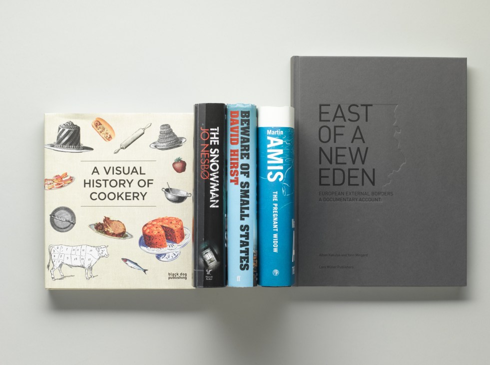 Five books displayed standing upright including A Visual History of Cookery, The Snowman, Beware of Small States, Swim, and East of a New Eden.