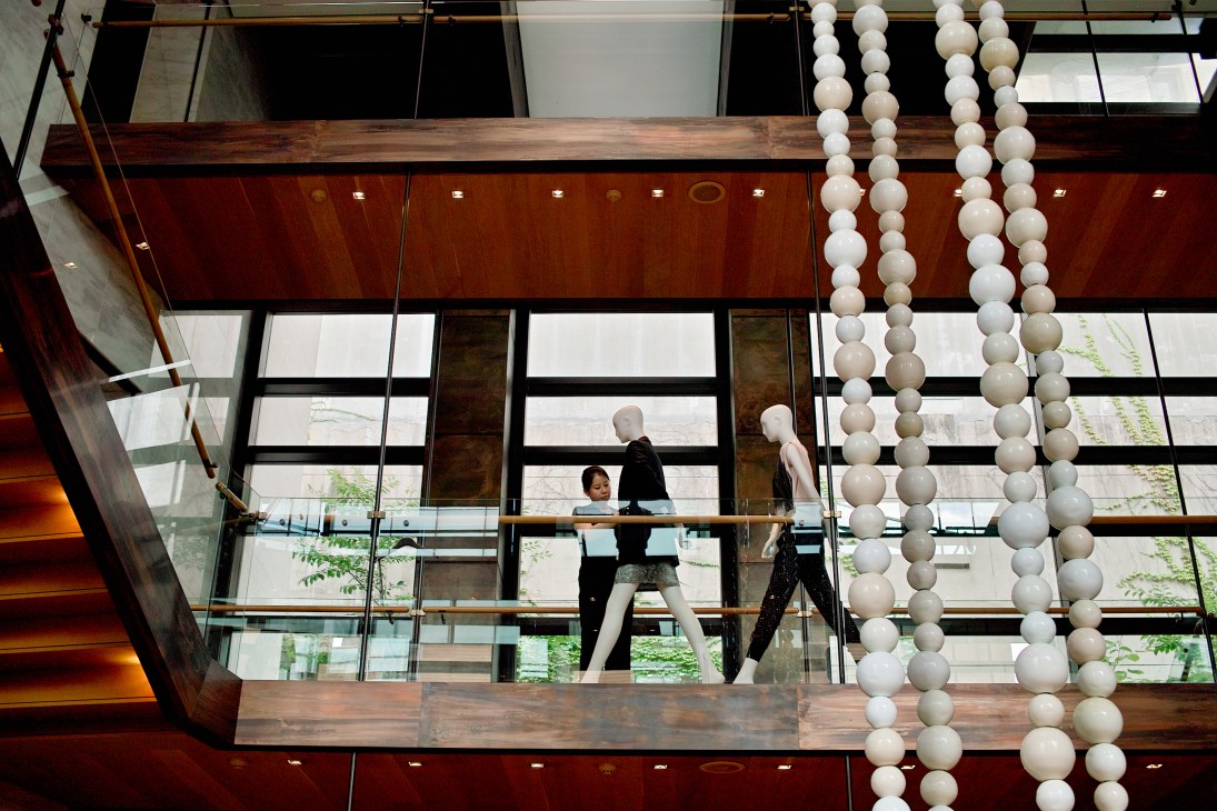 Overhead view of Boon The Shop atrium with customers on a wooden walkway surrounded by white spherical pendant lights.