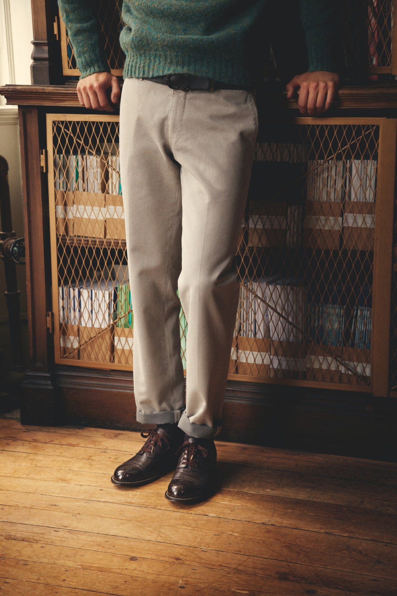 Man wearing cream trousers by Boglioli, green jumper by Beams Plus, black belt by Salvatore Ferragamo, and brown shoes by Foot the Coacher.