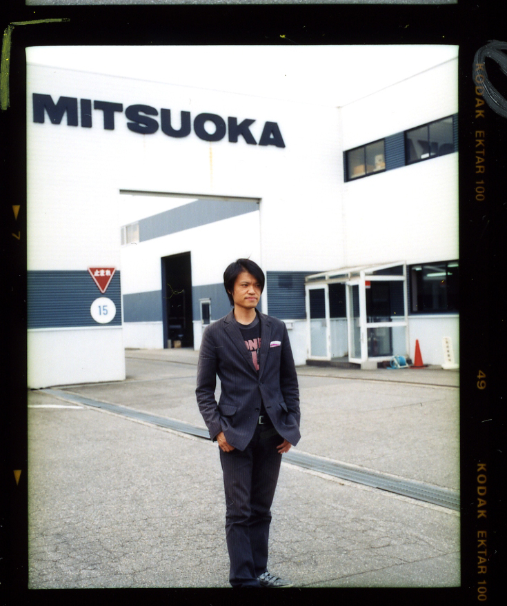 Acting plant manager Takanori Aoki stands in front of the Mitsuoka Motors factory building in Toyama.