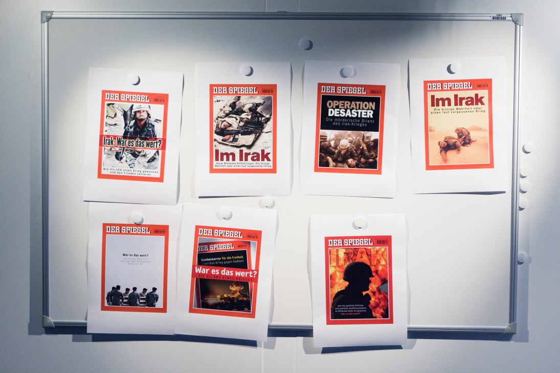 Multiple Der Spiegel magazine cover mockups displayed on a whiteboard, showing various Iraq war-related headlines and images.