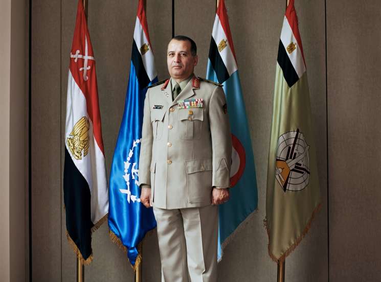 Mohammed Elkeshky, Egyptian defense attaché, in military uniform standing before Egyptian flags.