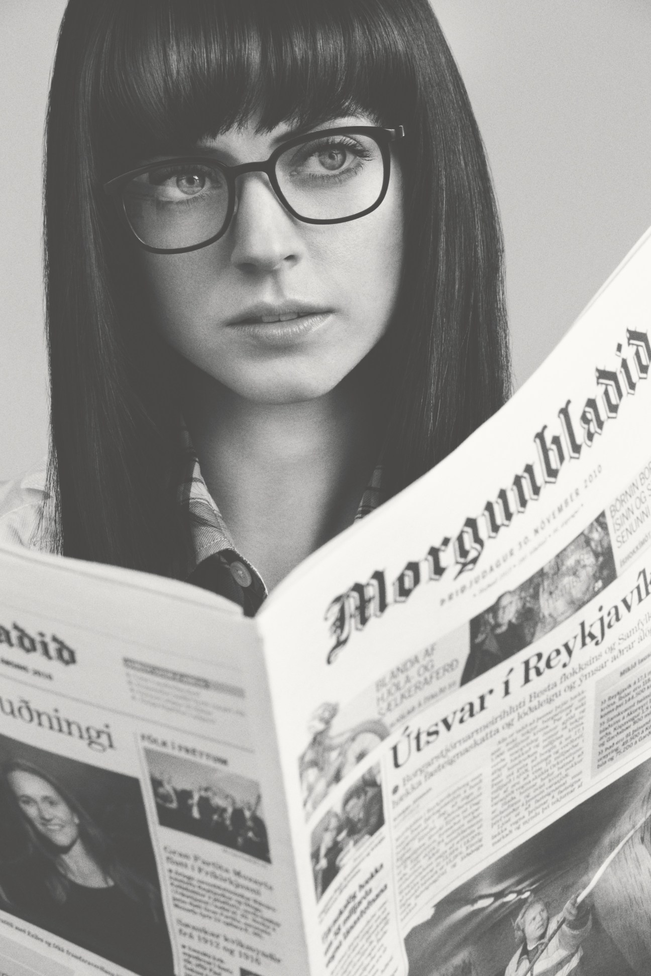 Woman wearing Lindberg Acetanium 1233 glasses reading a newspaper.