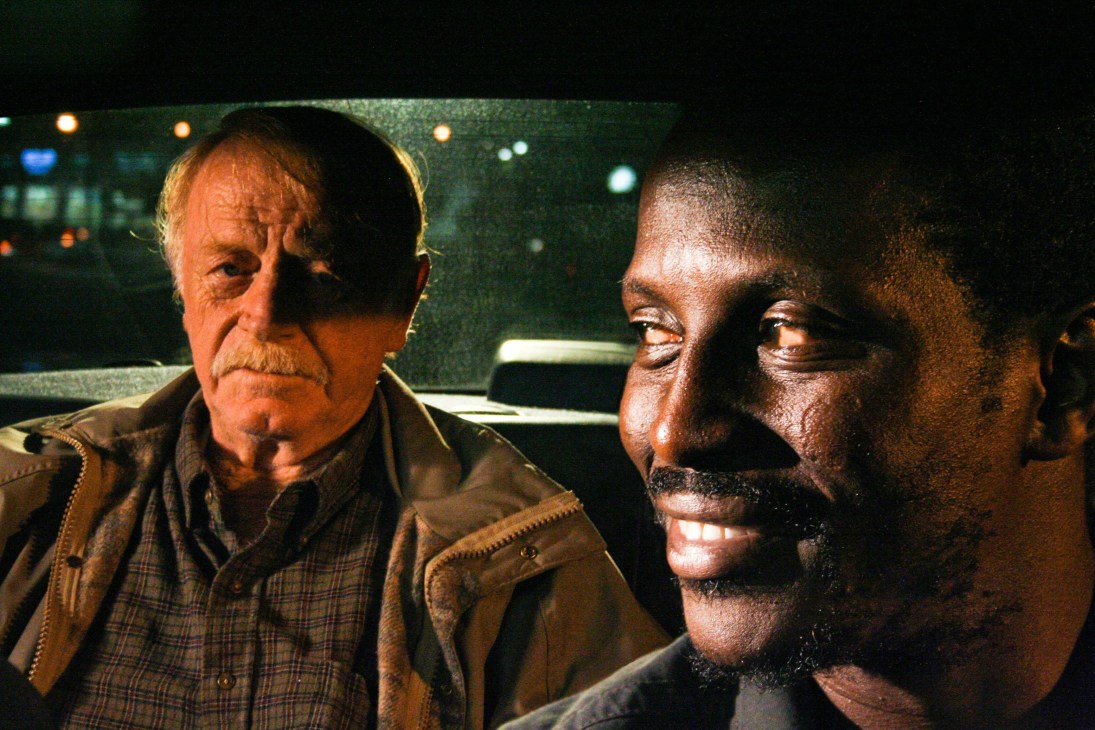 Two men conversing inside a car at night in a scene from the film Goodbye Solo.