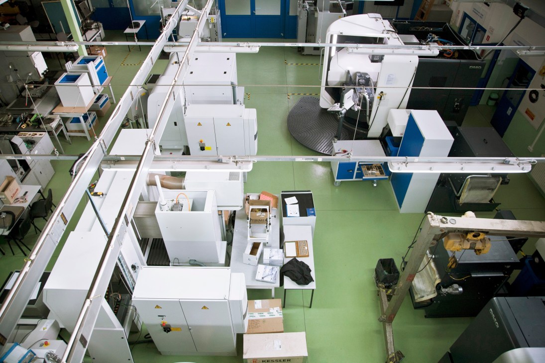 Overhead view of a modern technical laboratory with white equipment and green flooring at Rzeszów's technical university.