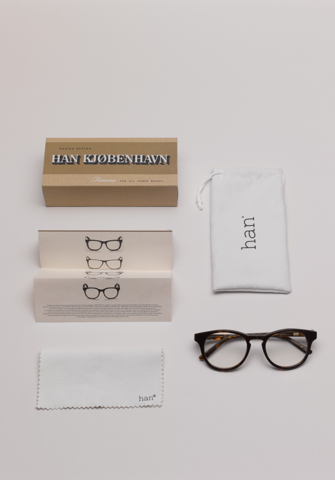 Han Kjøbenhavn eyewear packaging including cardboard box, frames, cloth pouch and cleaning cloth.