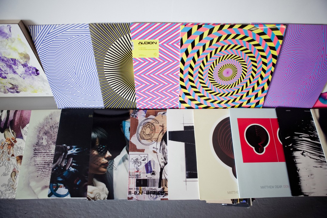 Collection of colorful and artistic record covers and album artwork displayed on a shelf.