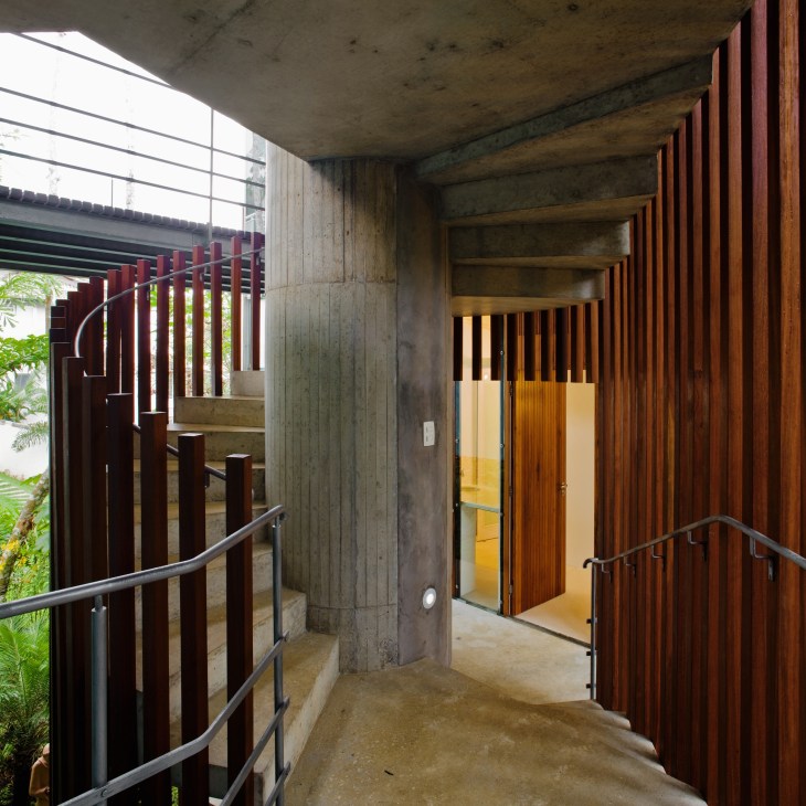 Spiral staircase with wooden slats and metal railing inside concrete structure