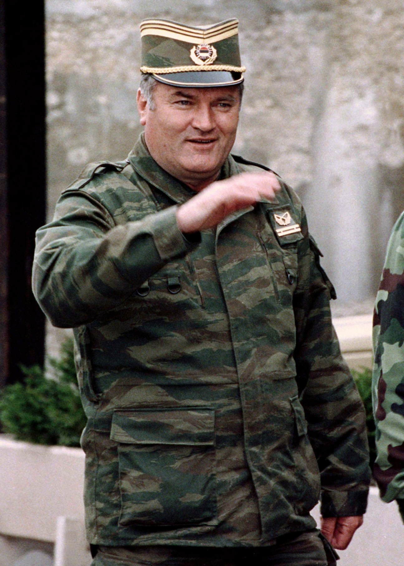 Ratko Mladic in military uniform and peaked cap, gesturing with his hand, photographed in 1993.
