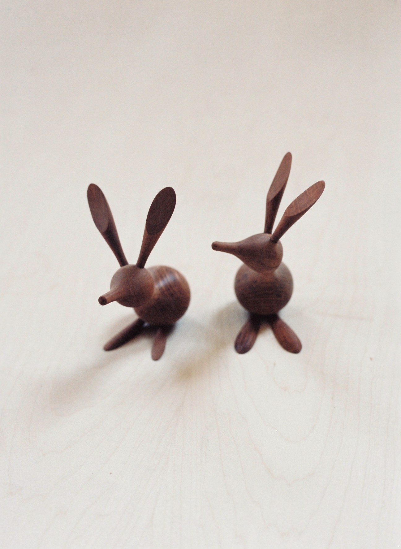 Two wooden kangaroo figurines hand-carved in dark wood, shown against a white background.