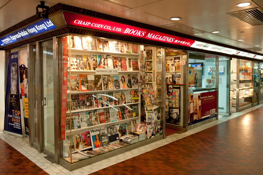 Chaip Coin magazine shop storefront in Hong Kong displaying magazines behind glass windows with red signage.