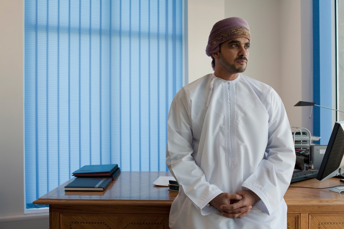 Faisal al Said, head of Brand Oman, stands in an office wearing traditional white kandura and headwear.