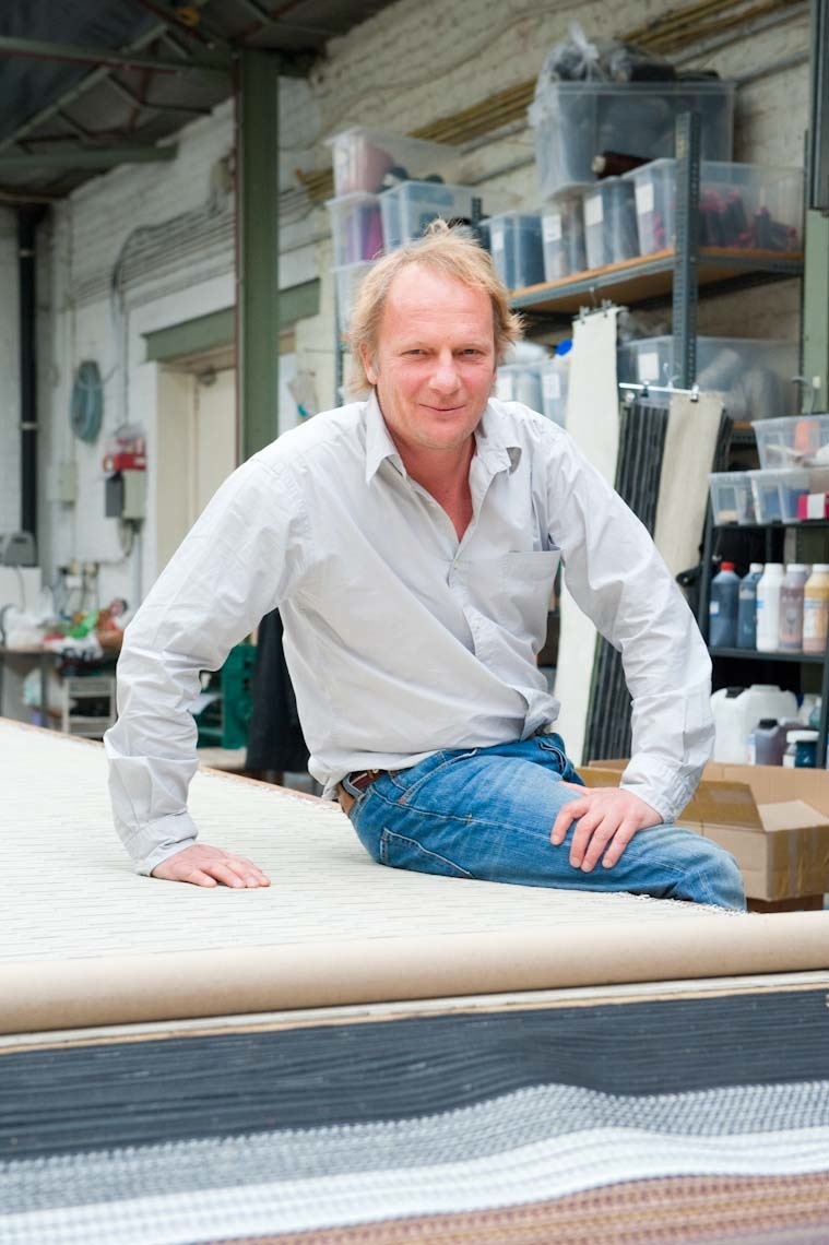 Nicolas Berryer, former investment banker, poses in the Atelier Charles Schambourg workshop beside woven leather samples.