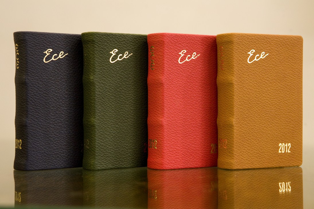 Four Ece diaries in black, green, red, and gold colors with white script branding and 2012 dates.