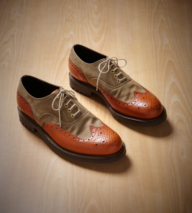Pair of Grenson x Barbour Marske brogues in burnished leather and canvas on wooden surface.