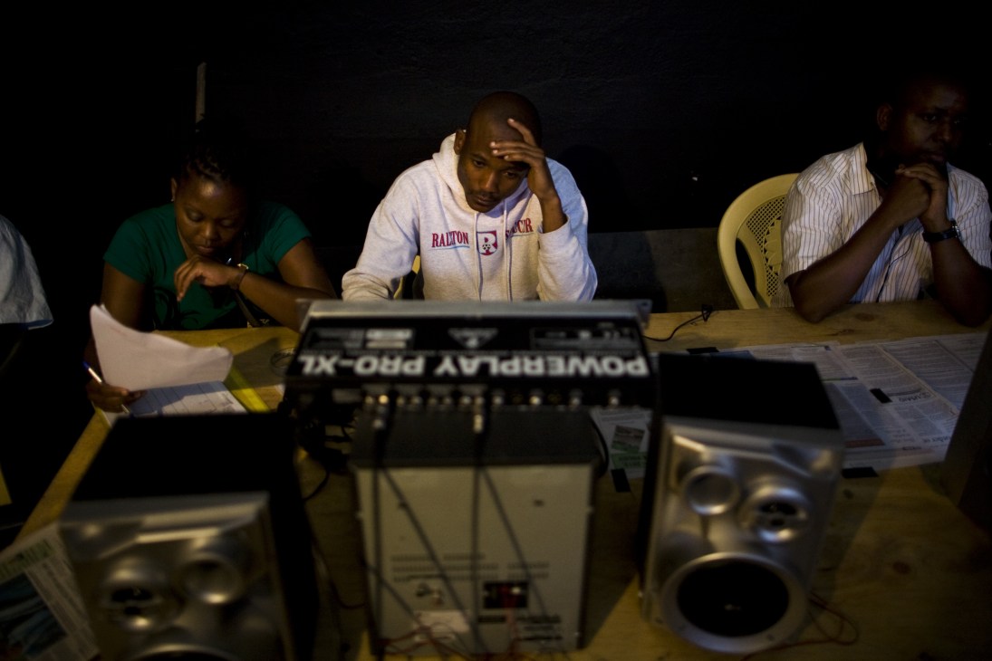 Film crew members working at a table with audio equipment during production of The XYZ Show.