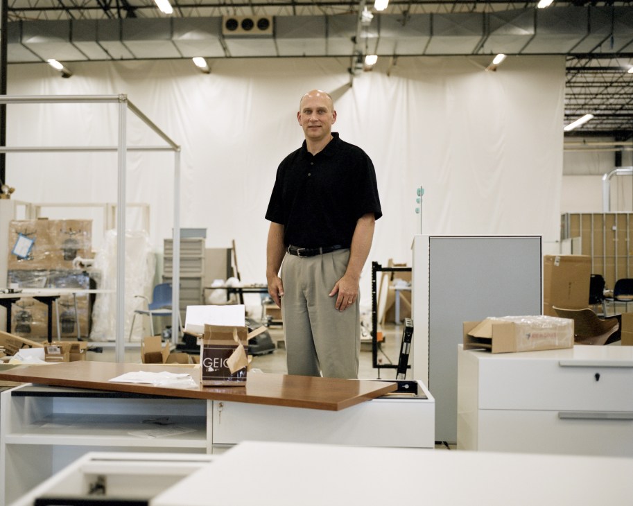 Gregg VanderKooi, production manager at Herman Miller, stands in a workshop among furniture prototypes and design pieces.