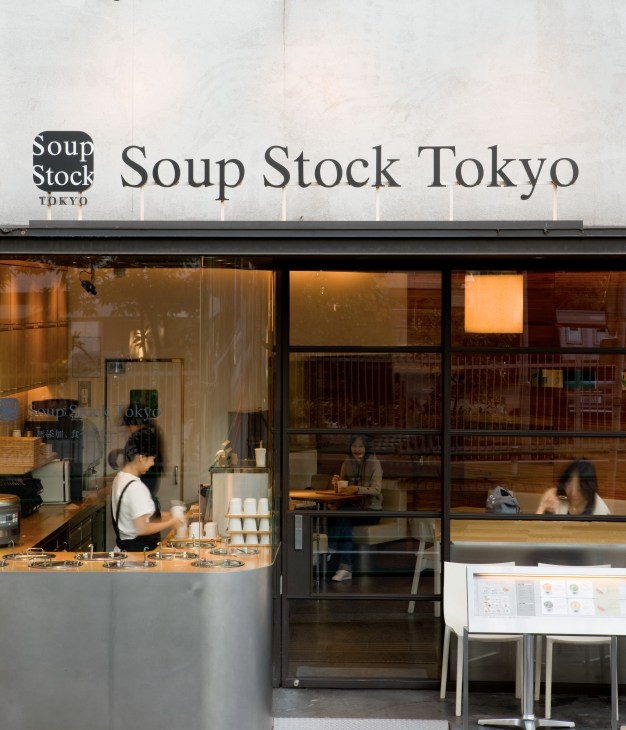 Soup Stock Tokyo storefront with black and white signage and interior counter service area in Tokyo.