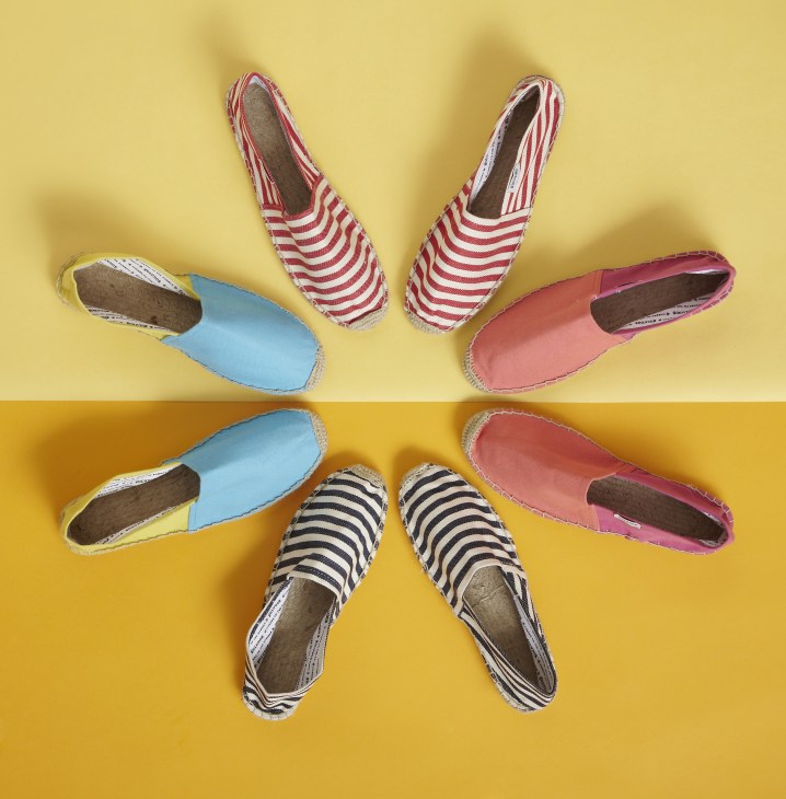 Six Soludos espadrilles in various colors and patterns arranged in a circle on a yellow background.