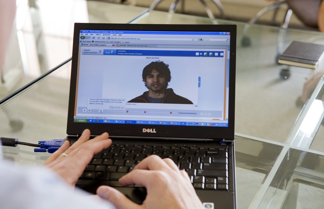 Person using Dell laptop displaying Efekta online learning platform with video instructor.