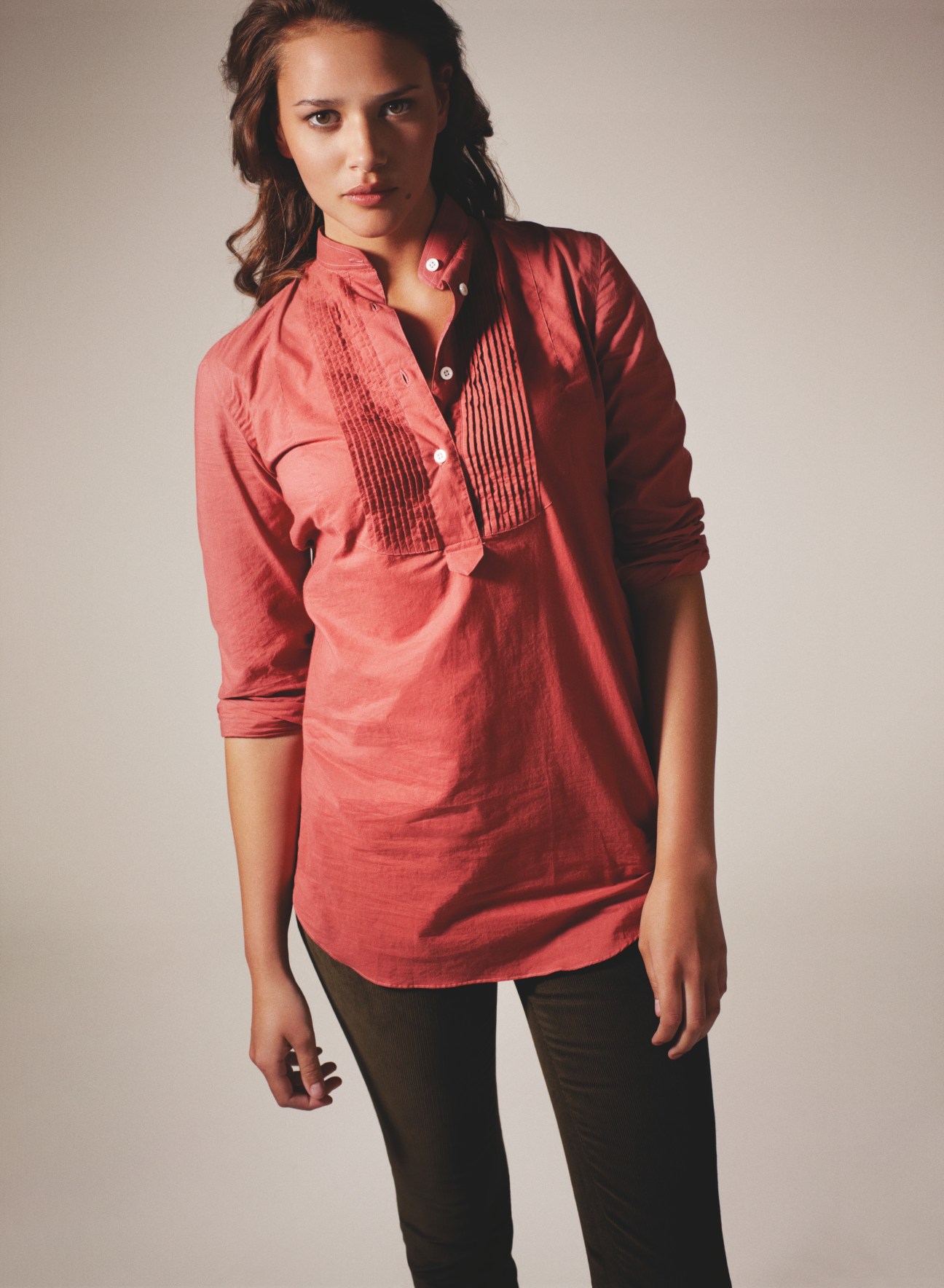 Woman wearing a coral-red shirt by Salvatore Piccolo and black trousers by Rag & Bone
