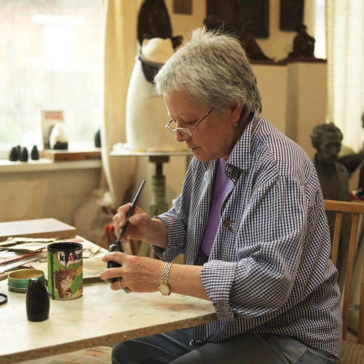 Artist Ludmila Bogatova paints a souvenir at her studio workbench.