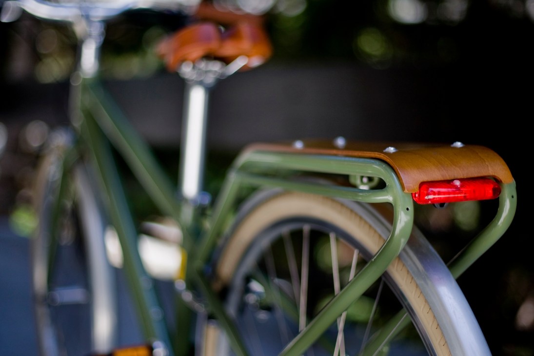 Close-up of a Globe HAUL bike's rear rack in olive green with a red light