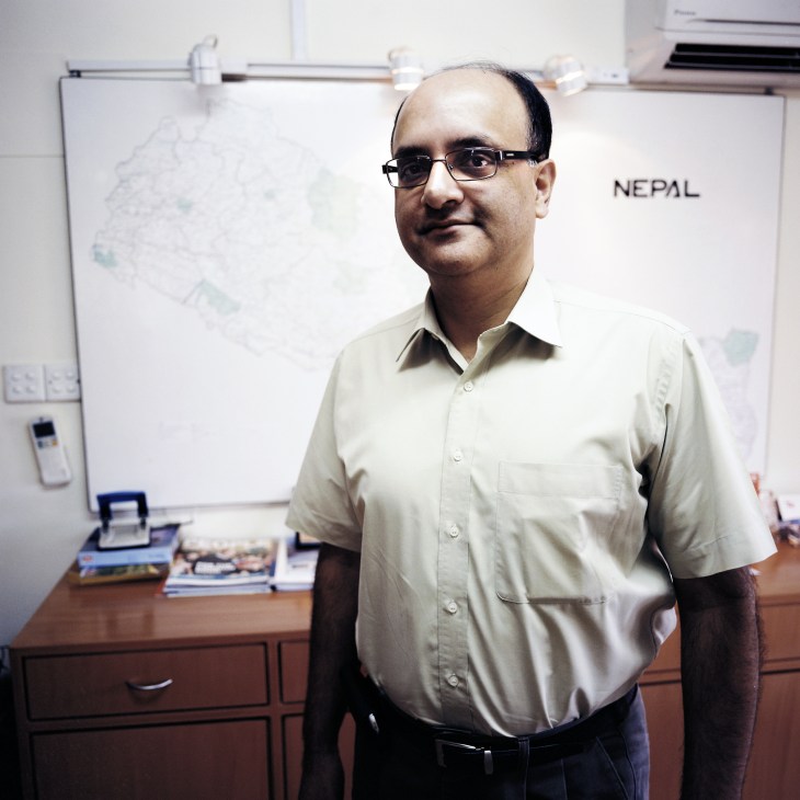 Sandip Shah, vice president and country director of SN Power, standing in an office with a Nepal map on the wall behind him.