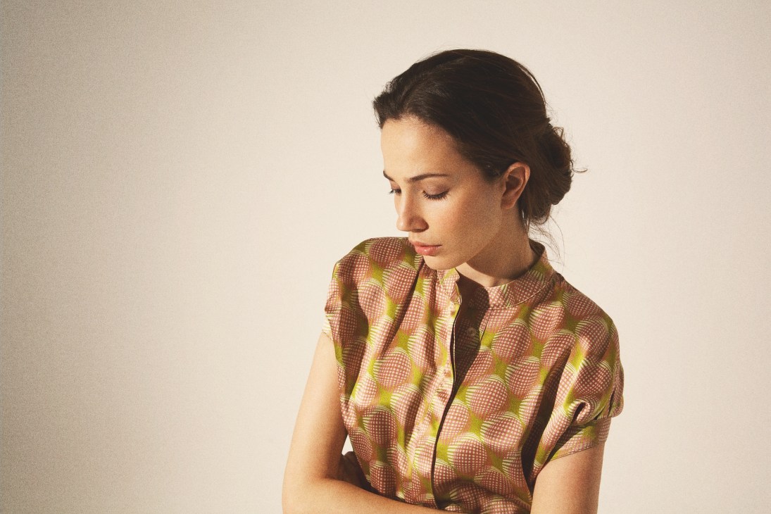 Woman wearing a kimono-inspired patterned shirt with red, green and yellow geometric design