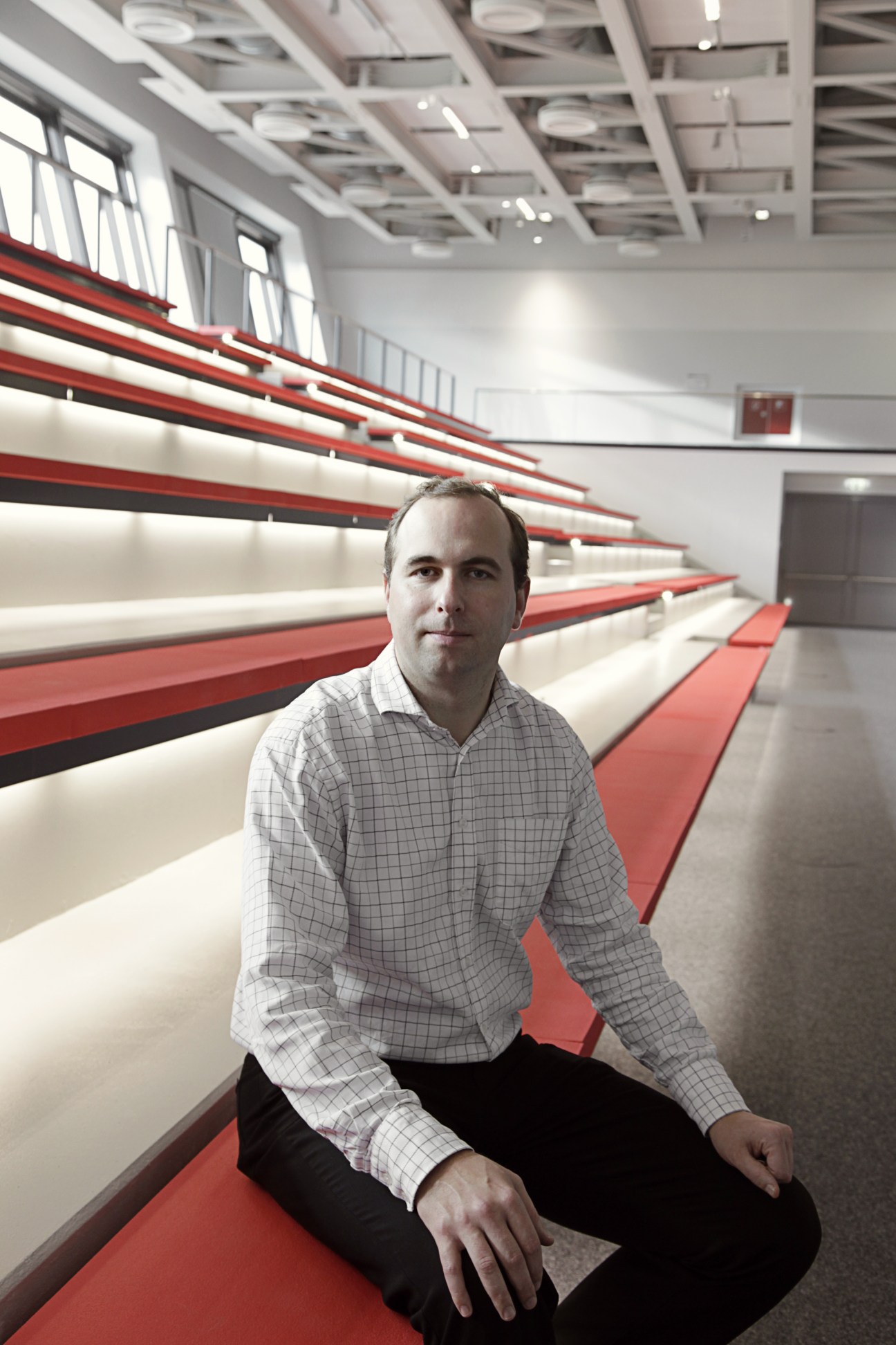 Filip Trulsson, senior manager at Puma's team sport division, sits on red and white shelving at Puma headquarters in Herzogenaurach, Germany.