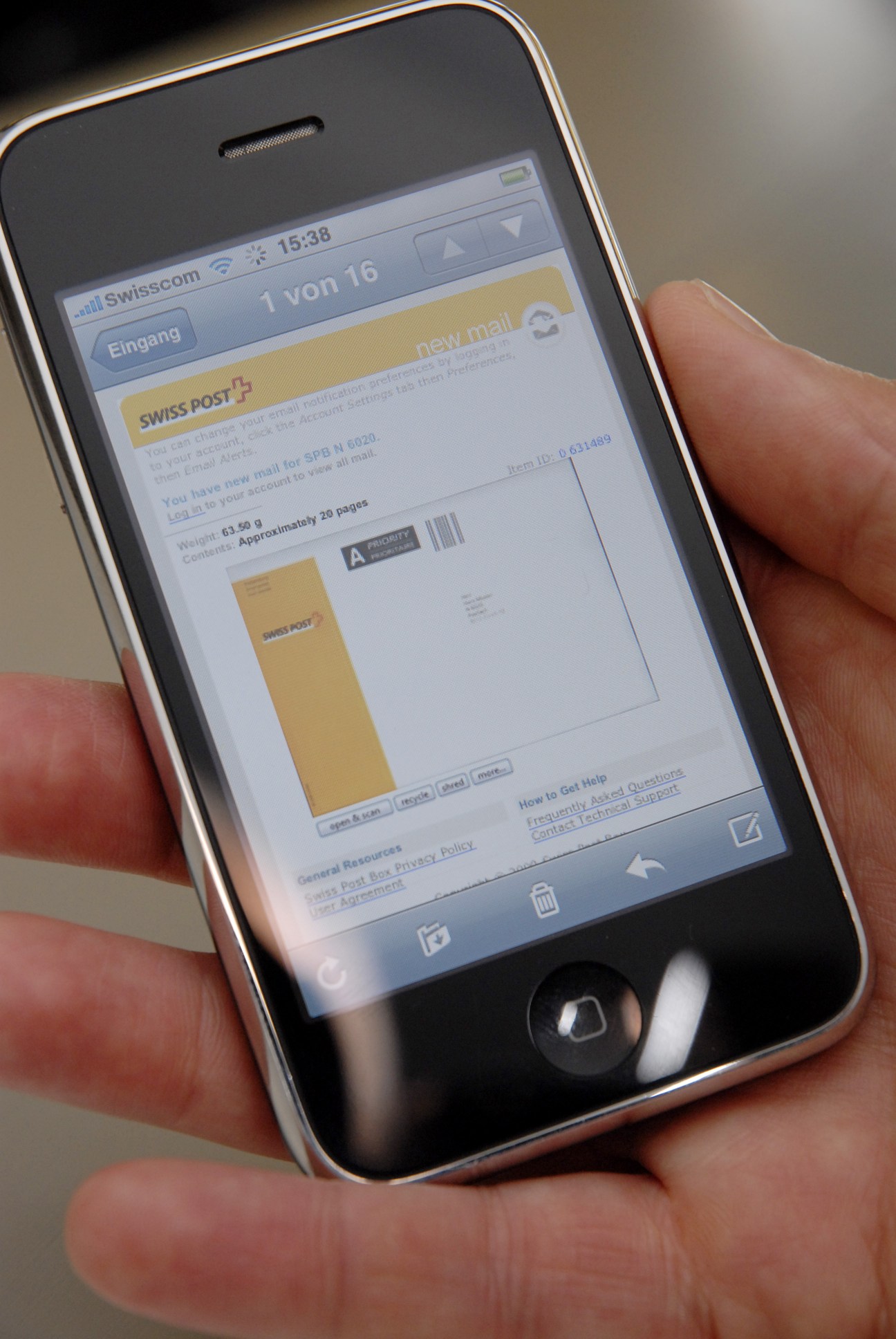 Hand holding an iPhone displaying the Swiss Post Box application interface with new mail notification.