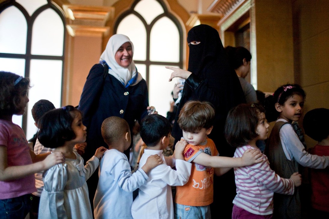 Children participate in an art class at the Emirati Expressions Exhibition at Emirates Palace, guided by female instructors.