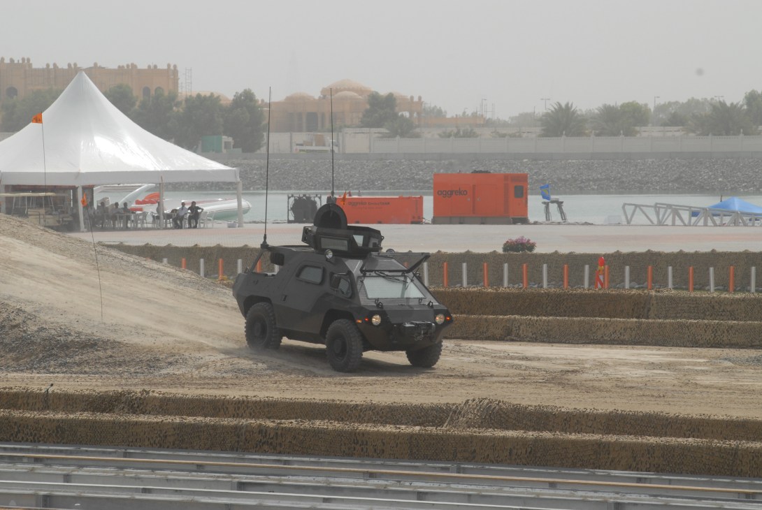 Armored military vehicle driving across demonstration grounds at IDEX exhibition in Abu Dhabi