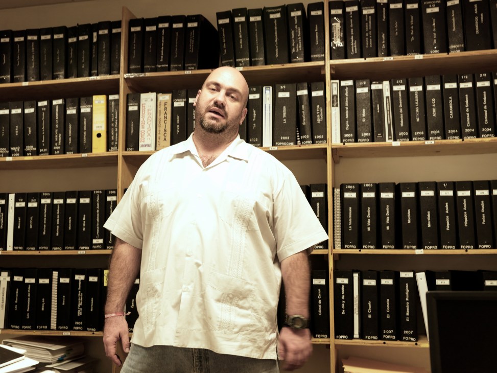 Hugo Villa, production director at the Mexican Film Institute, standing in front of shelves of film archives.