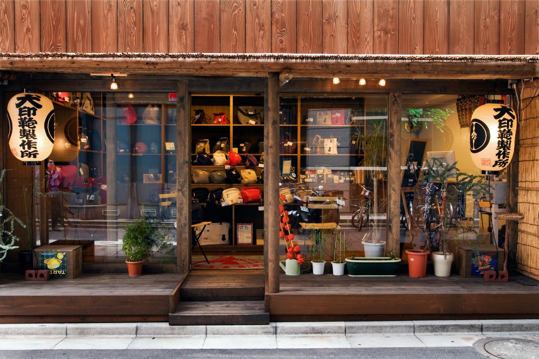 Inujirushi's wooden storefront in Asakusa displaying canvas bags and accessories in window displays with lantern signage.
