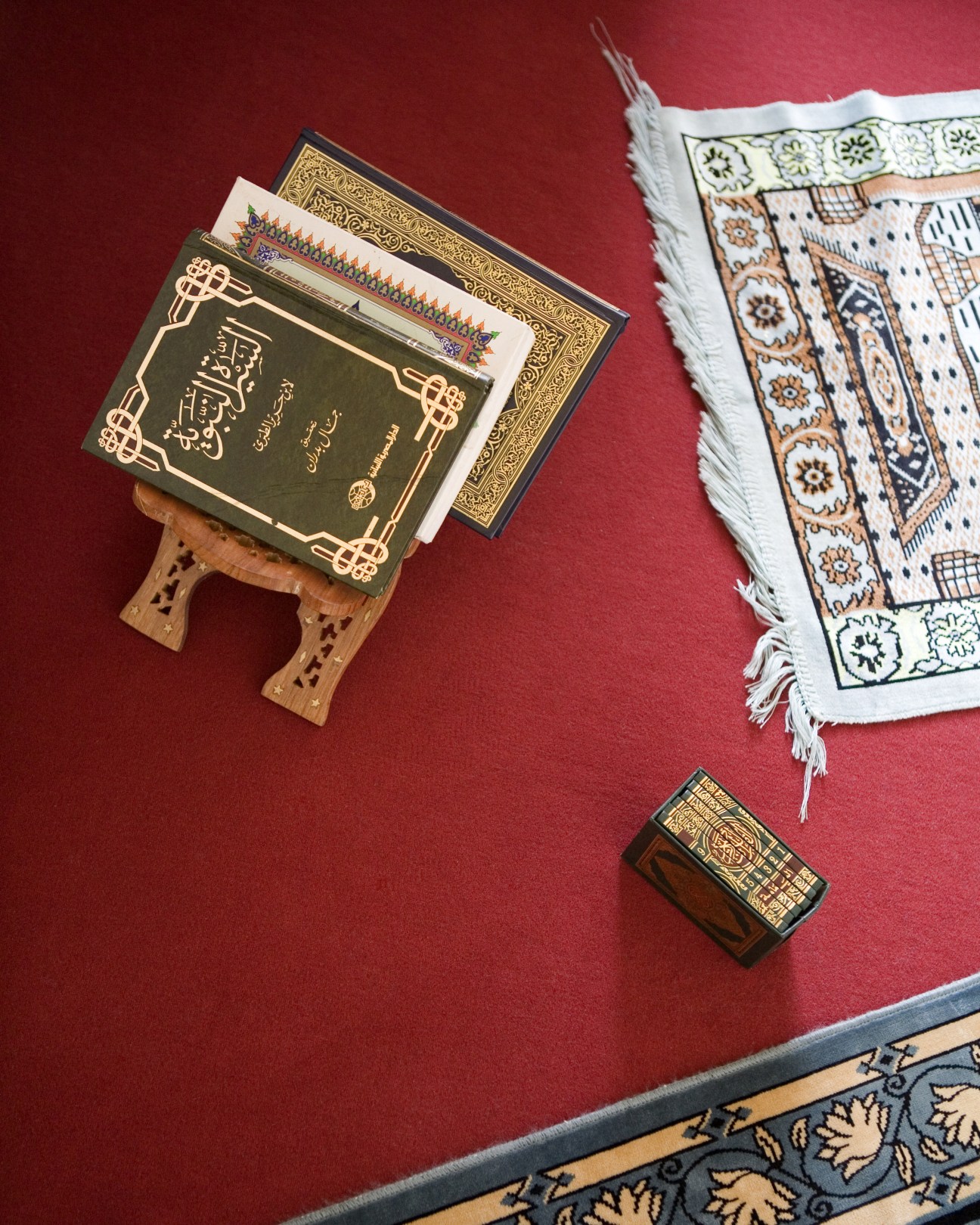 Koran and prayer mat displayed on a red surface at UKE hospital.