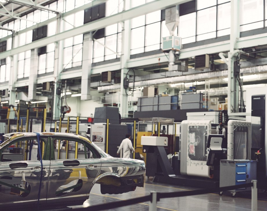 Car manufacturing facility with worker and industrial machinery at Warwick Manufacturing Group.