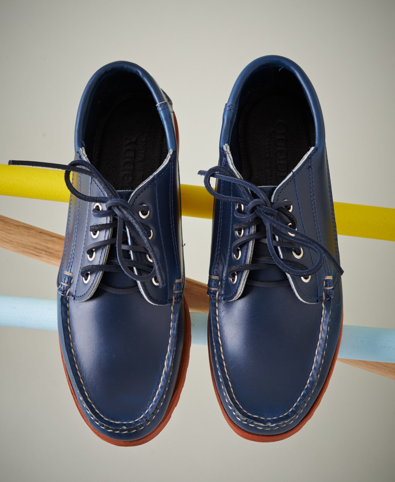 Pair of navy leather Quoddy Maliseet Oxford shoes with red rubber Vibram sole, displayed from above.
