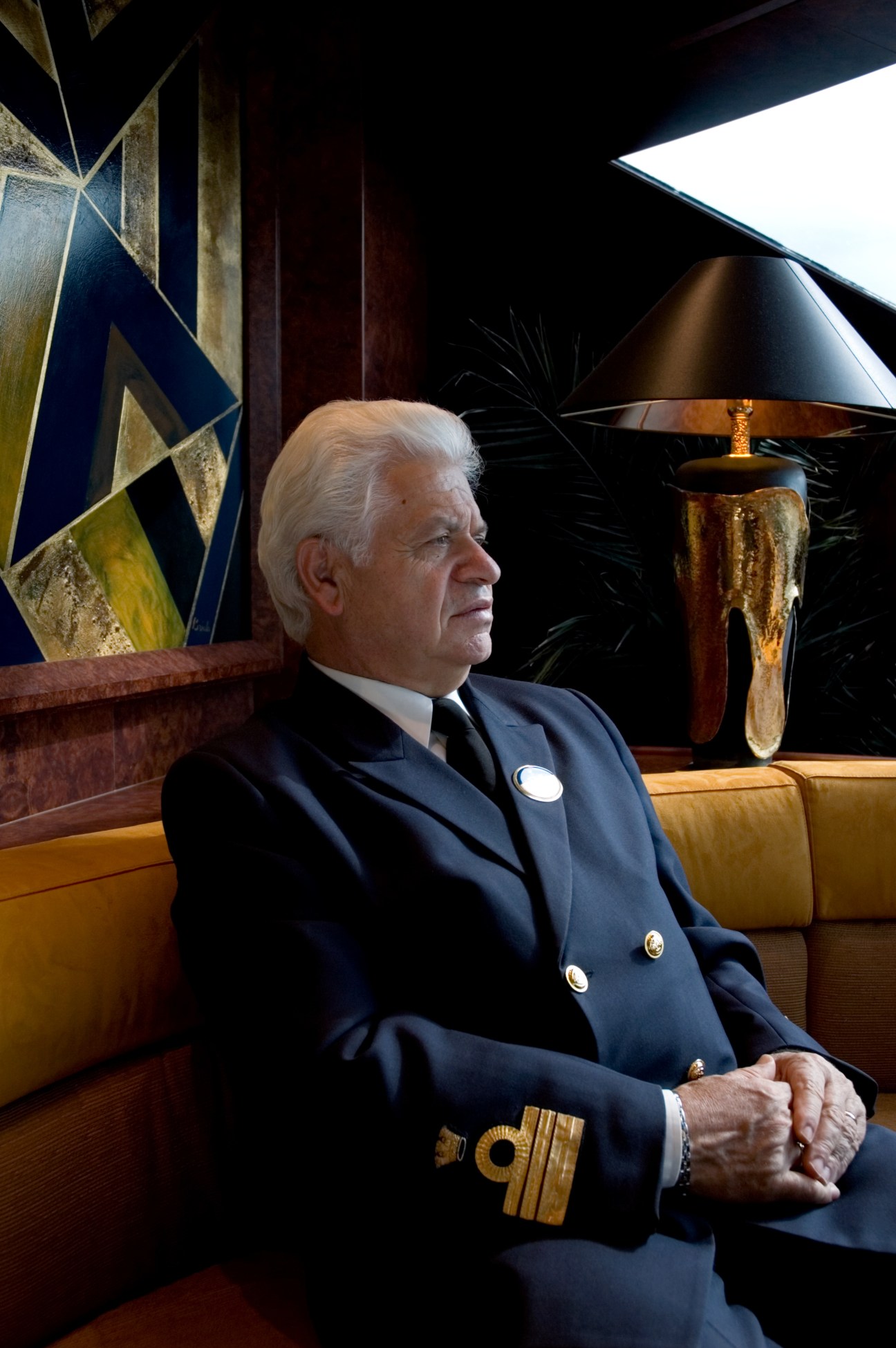 Captain Ferdinando Ponti in formal navy uniform with gold braid, seated in an elegant cabin interior.